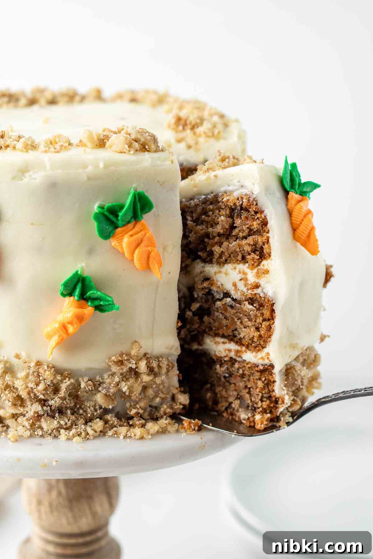 A slice being cut from a carrot cake.