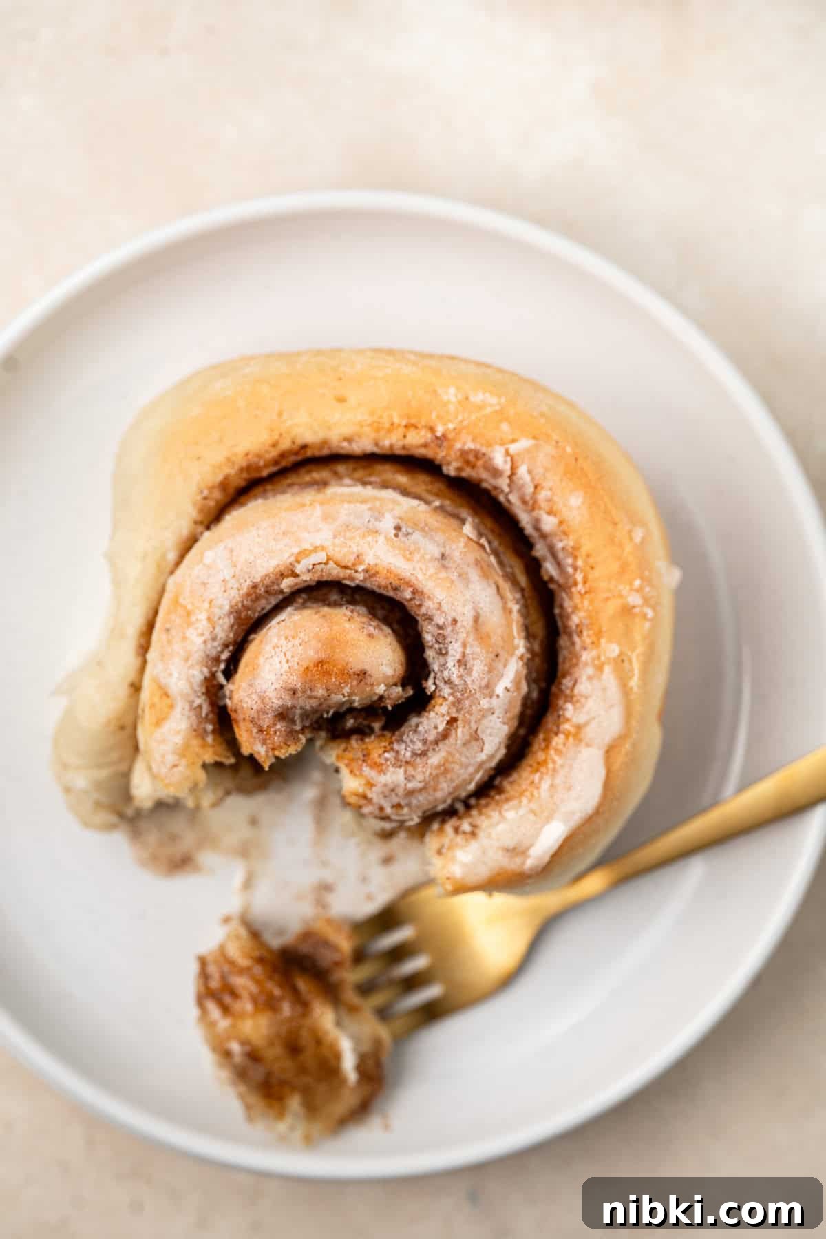 A single cinnamon roll on a plate.