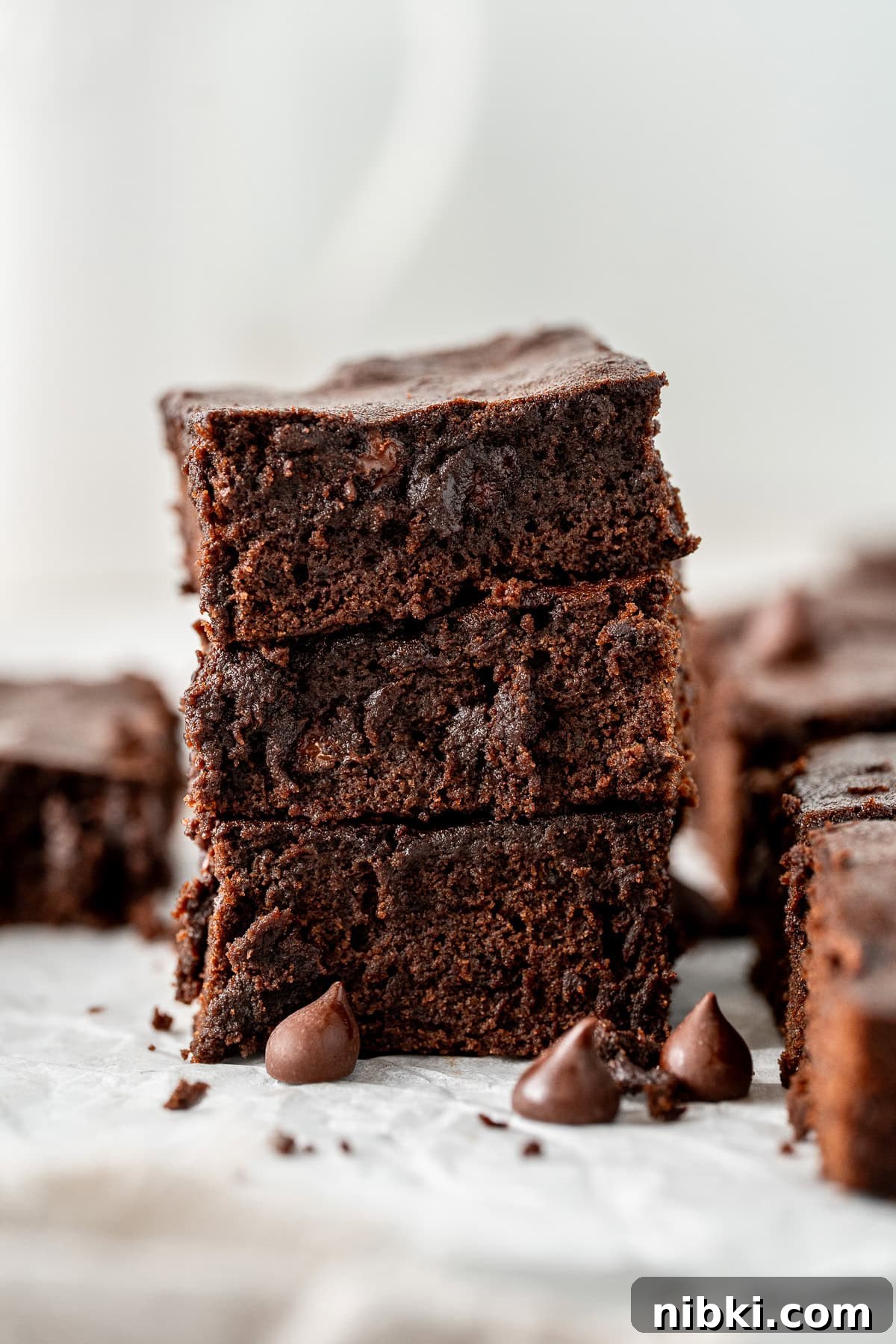 Dairy free chocolate brownies stacked on top of each other.