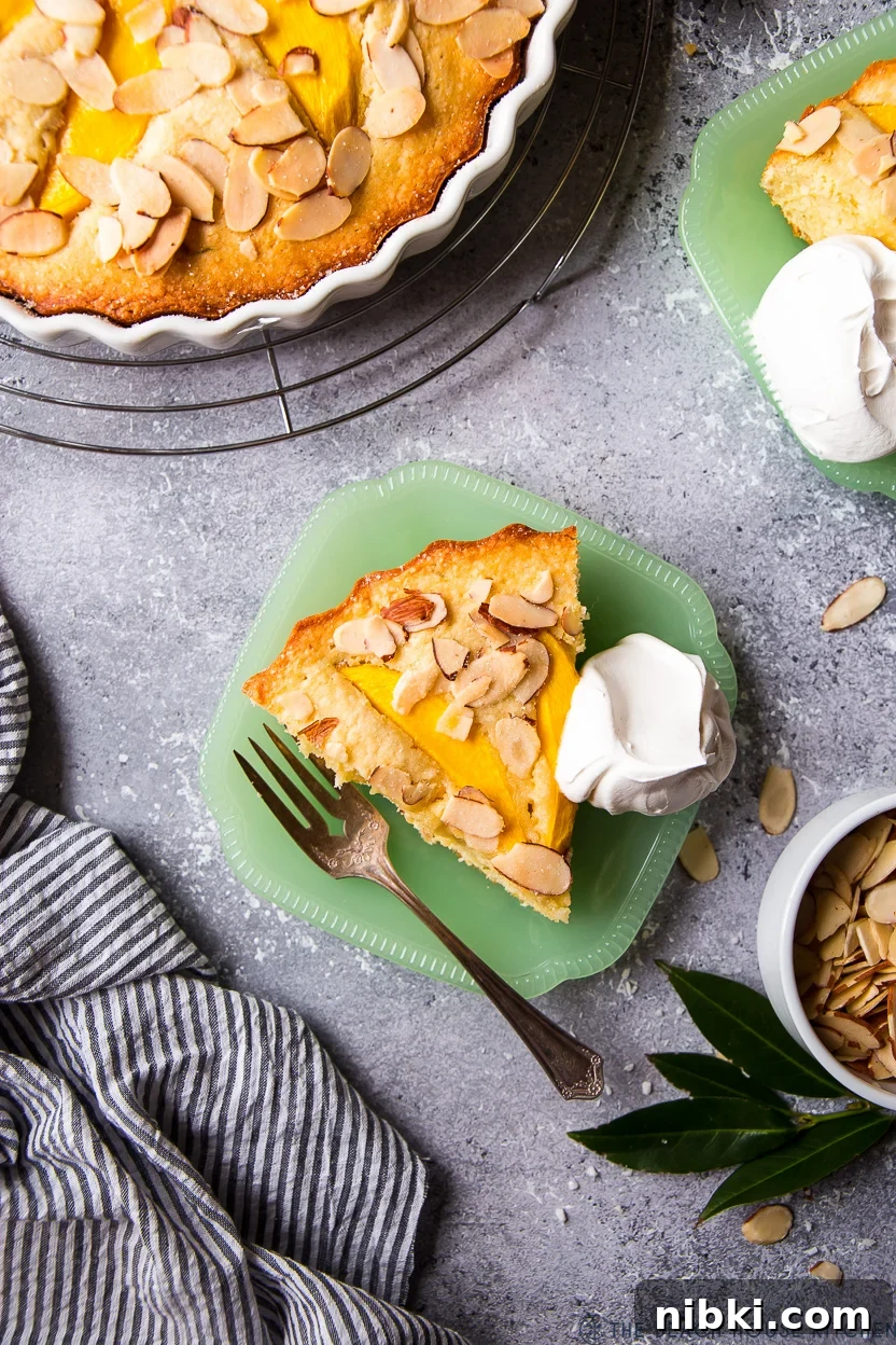Tropical Mango Almond Cake Recipe 3 Overhead photo of a slice of mango cake on a green plate with a fork and some whipped cream.