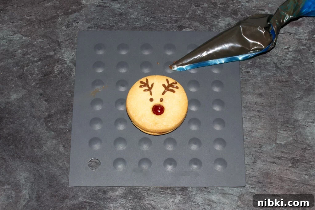 A reindeer cookie with the chocolate eyes and antlers piped on