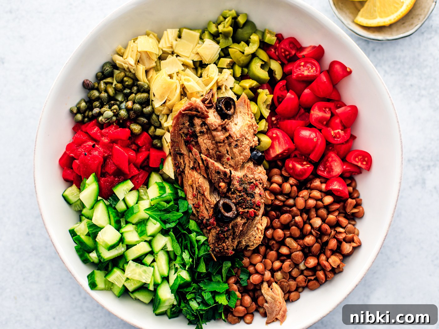 Bowl with chopped veggies and fillet of mackerel laid on top.