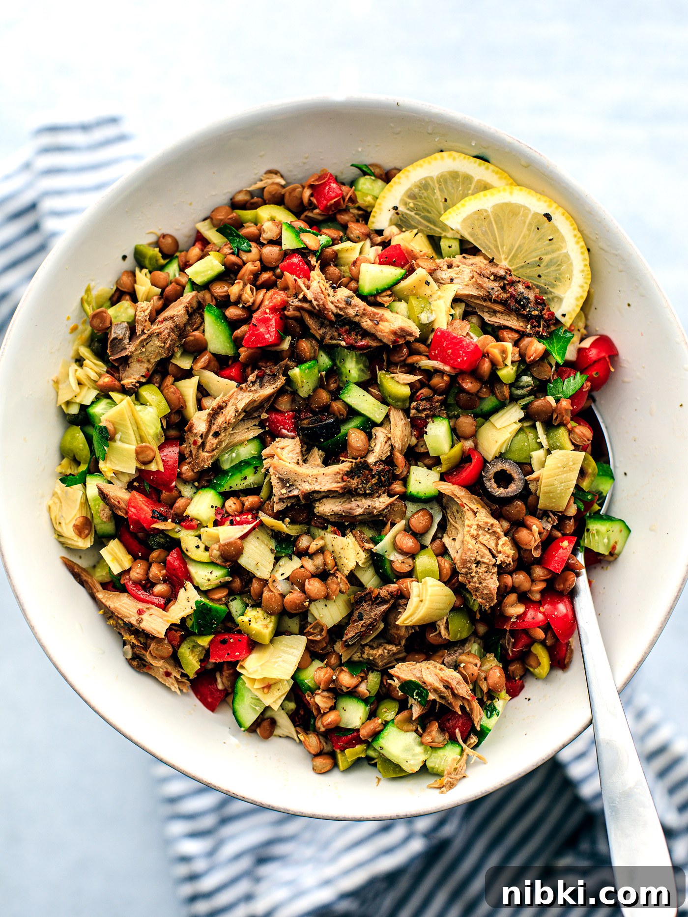 White serving bowl full of Greek lentil salad.