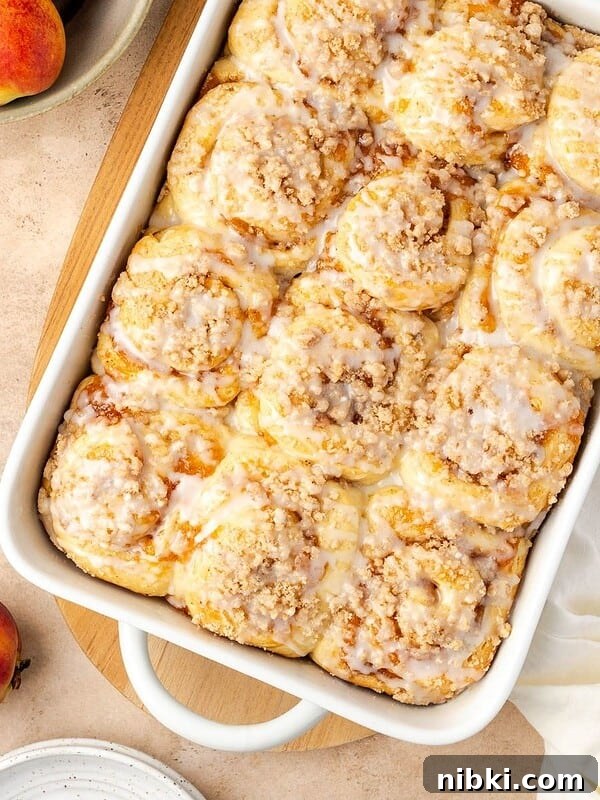 Peach cobbler cinnamon rolls in a baking dish.
