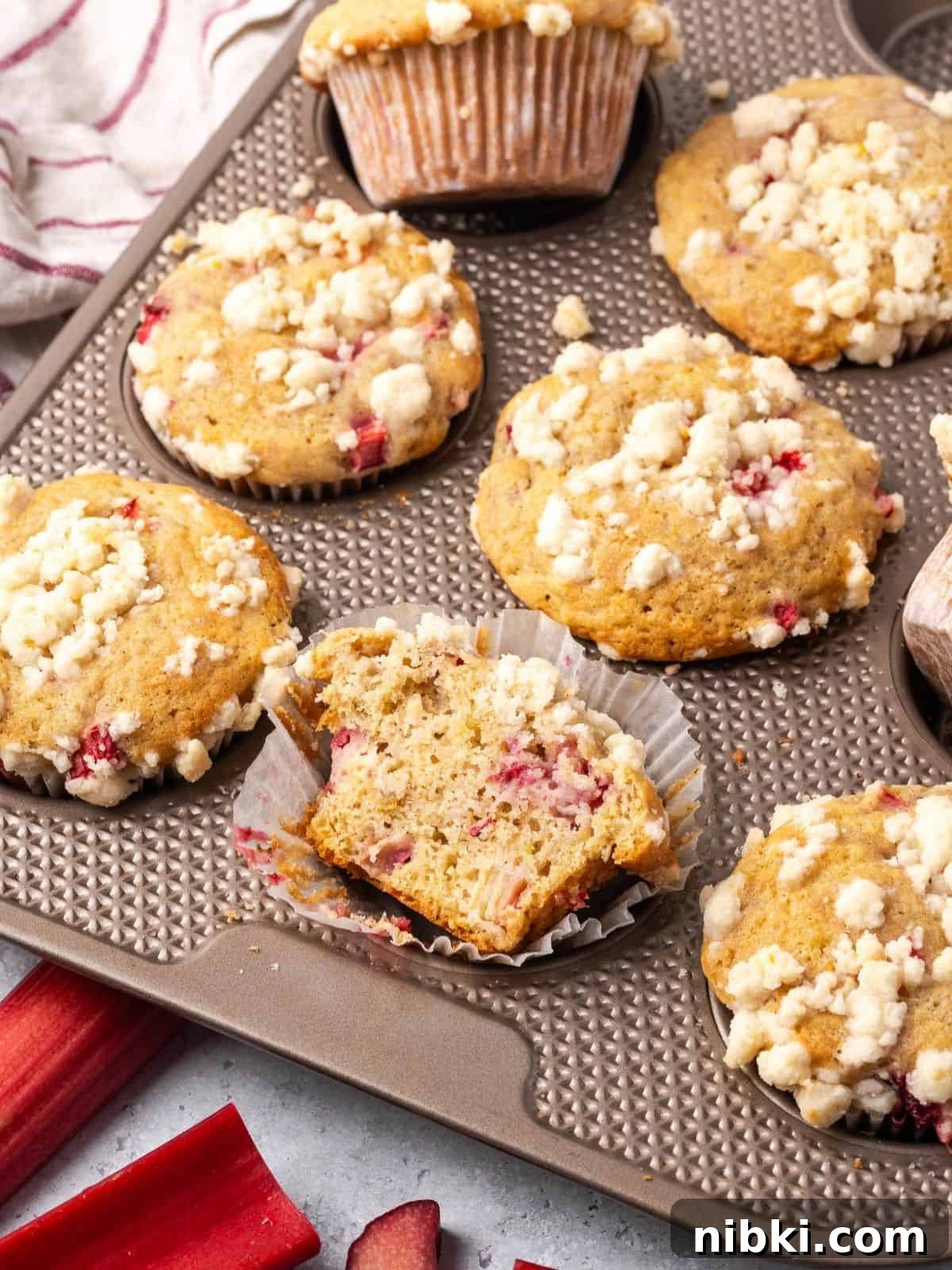 Strawberry Rhubarb Muffins with Lemony Streusel Topping 9 Baked strawberry rhubarb muffins with lemon streusel topping in a muffin tin.