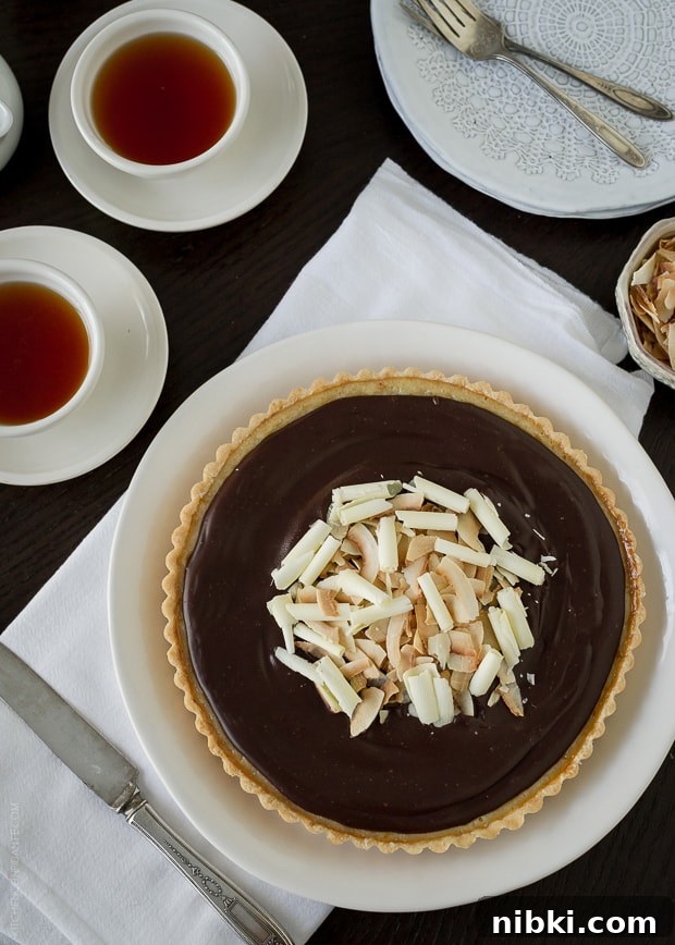 Coconut Custard Tart with Chocolate Ganache Recipe 5 Coconut Custard Tart with Chocolate Ganache on a white serving plate.