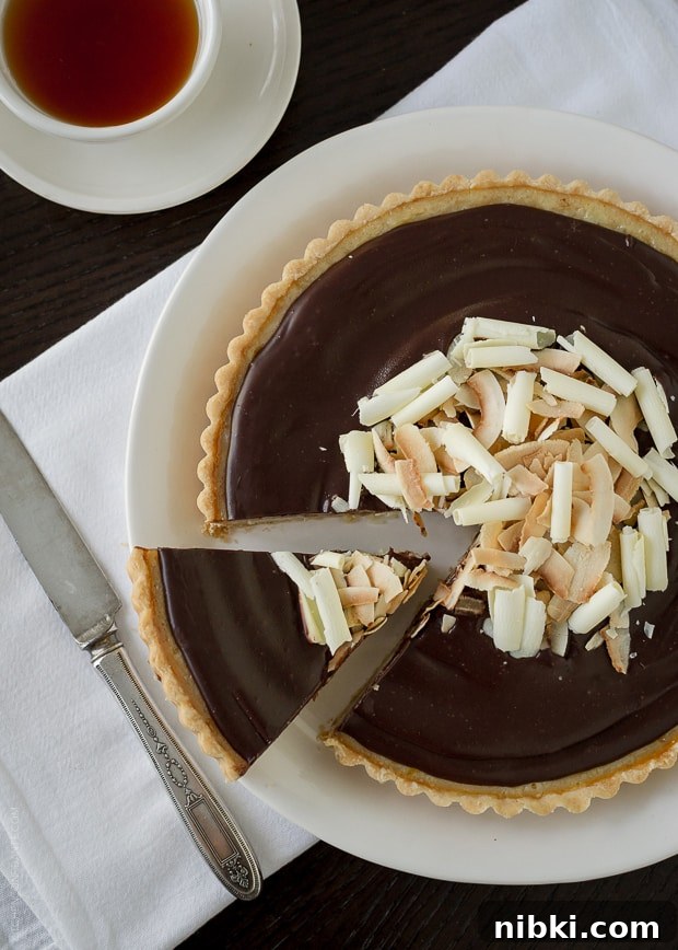 Coconut Custard Tart with Chocolate Ganache Recipe 7 Removing a slice from a chocolate-topped tart.