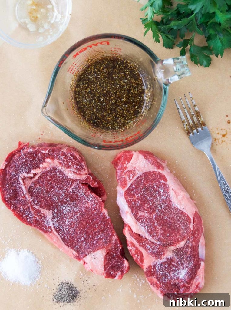 Garlic Herb Ribeye Steak Marinade for Grilling 4 Two ribeye steaks sit next to a bowl of marinade