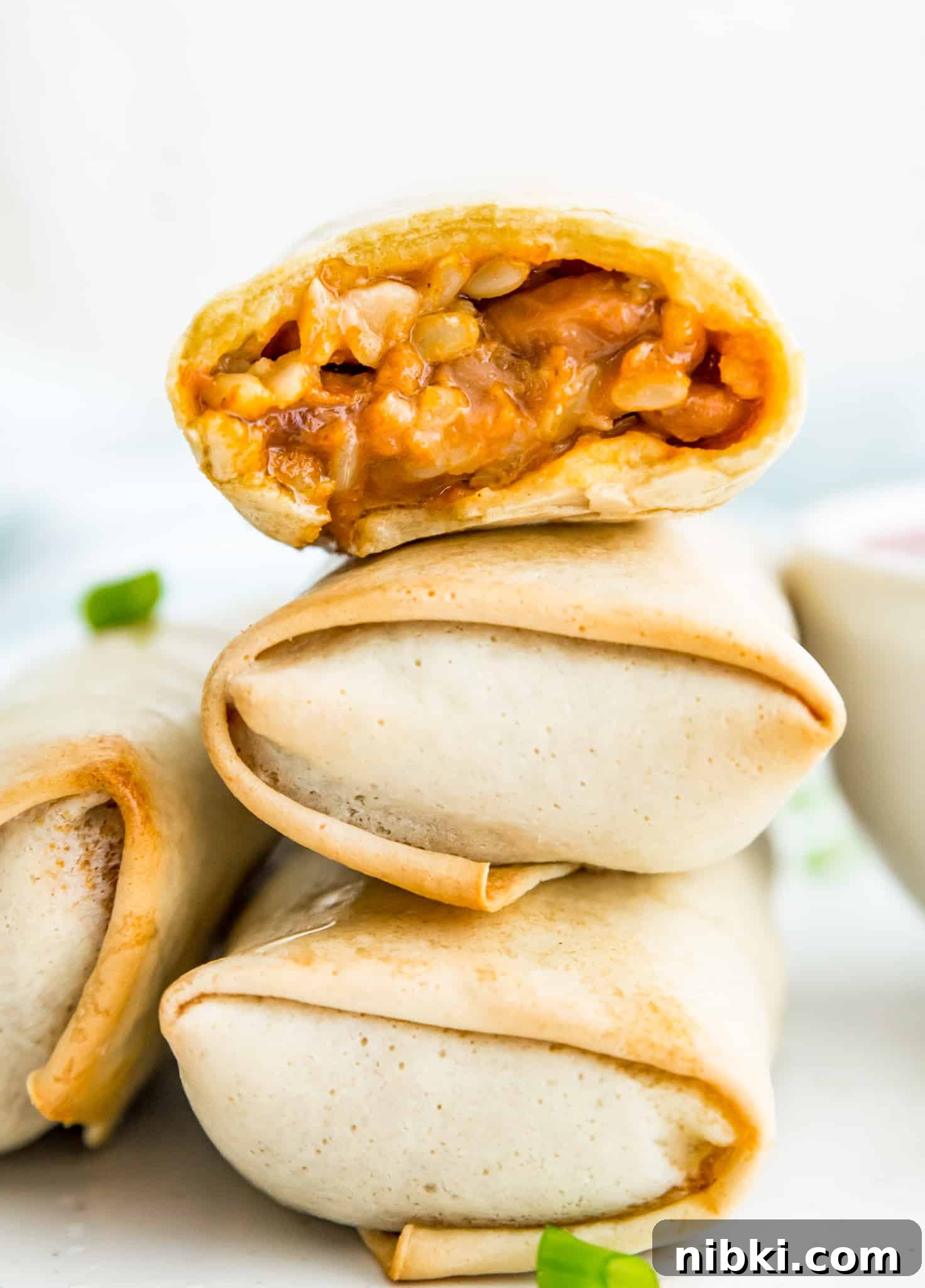 How to Air Fry a Frozen Burrito for Crispy Results 2 A stack of three cooked burritos, and the top one has a bite taken out of it.