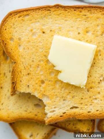 A stack of toast with a slab of butter on top.