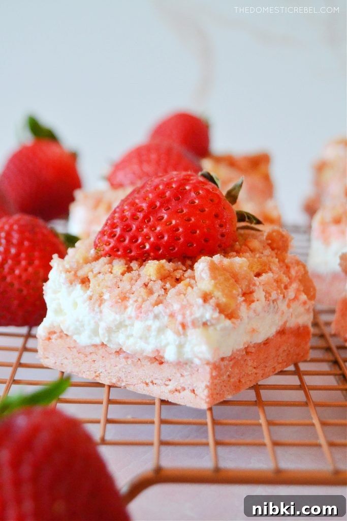 a strawberry crunch bar on a wire rack with strawberries around it