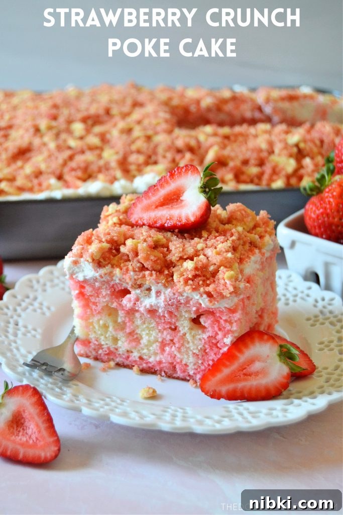 fresh strawberries and a strawberry crunch poke cake piece on a white plate