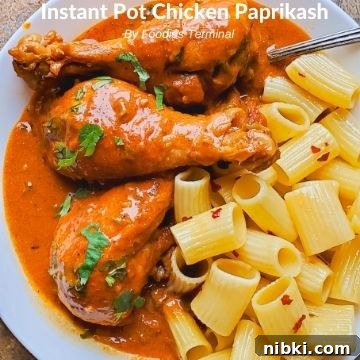 chicken paprikash with drumsticks served on a white plate with buttered pasta on the side