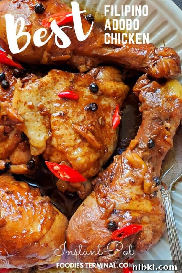 instant pot chicken adobo served in plate with spoon garnished with red thai chilies