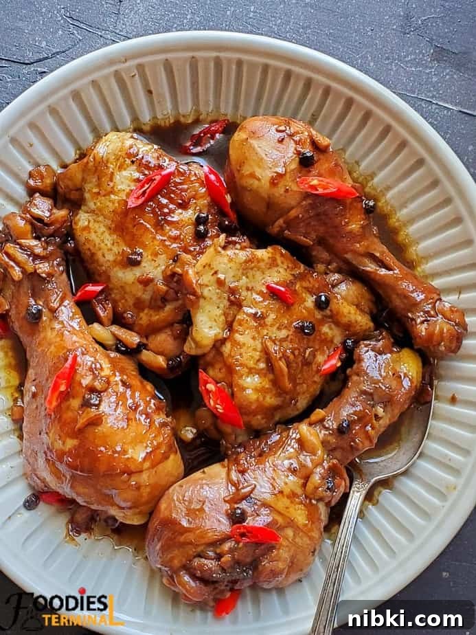 chicken adobo served in beige plate with spoon