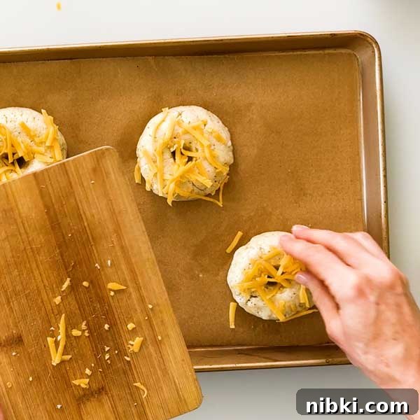 Cheddar Protein Bagels Without Yeast 8 Sprinkling cheddar cheese on top of the bagels.