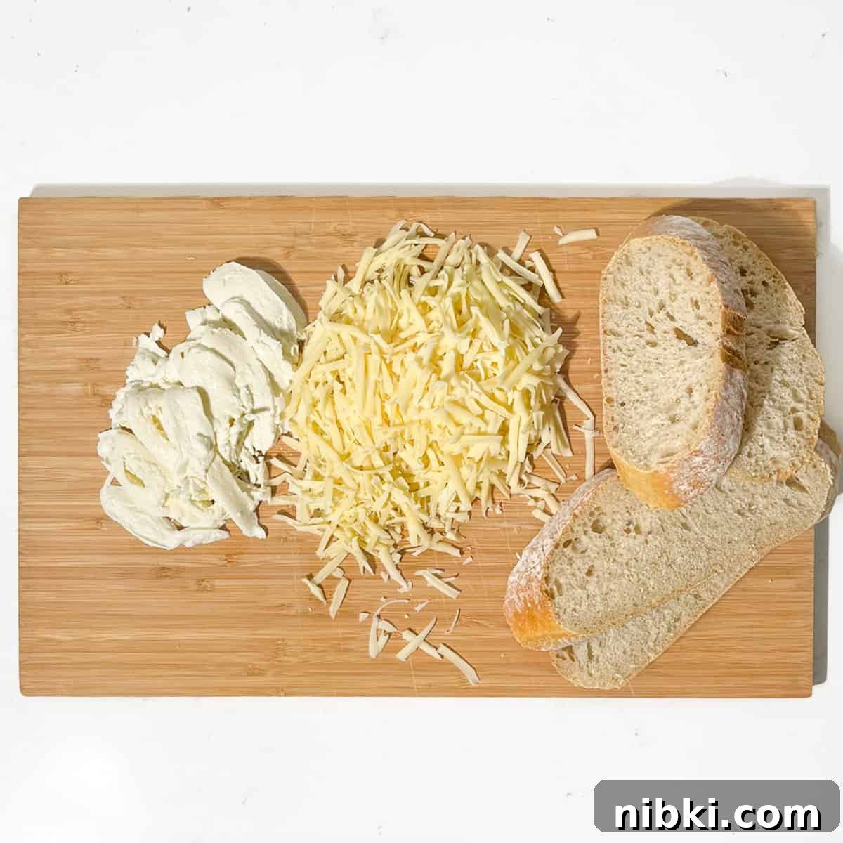 Grated and sliced cheese and bread for the sourdough grilled cheese sandwich.
