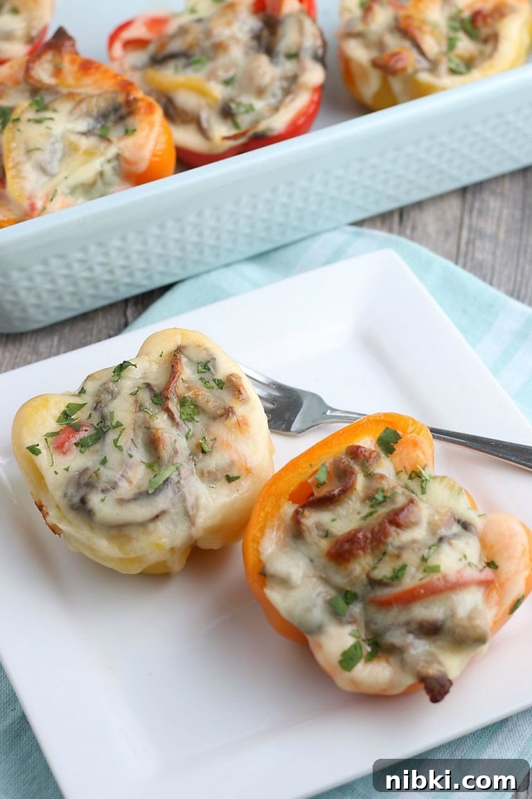 Philly Cheesesteak Stuffed Peppers - Low-Carb, Gluten-Free 2 A look at two stuffed peppers on a plate ready to be enjoyed or shared.