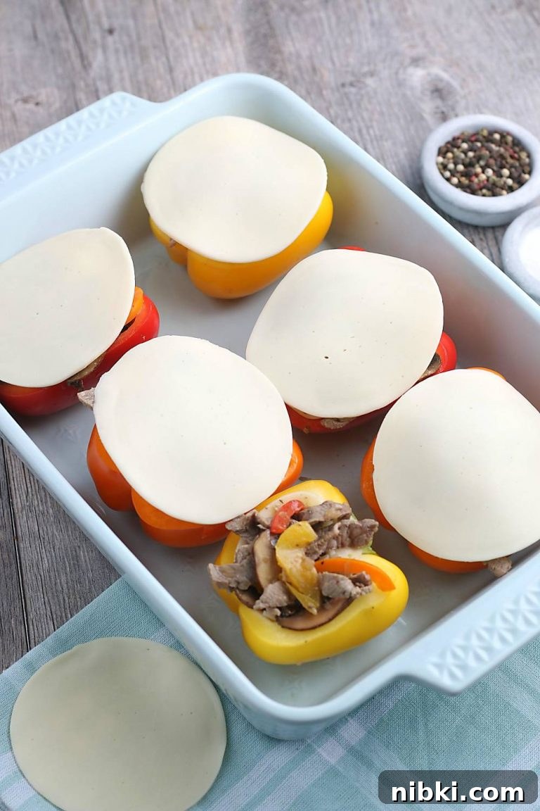 Philly Cheesesteak Stuffed Peppers - Low-Carb, Gluten-Free 5 The slices of provolone are added on top of the keto stuffed peppers before they go into the oven.