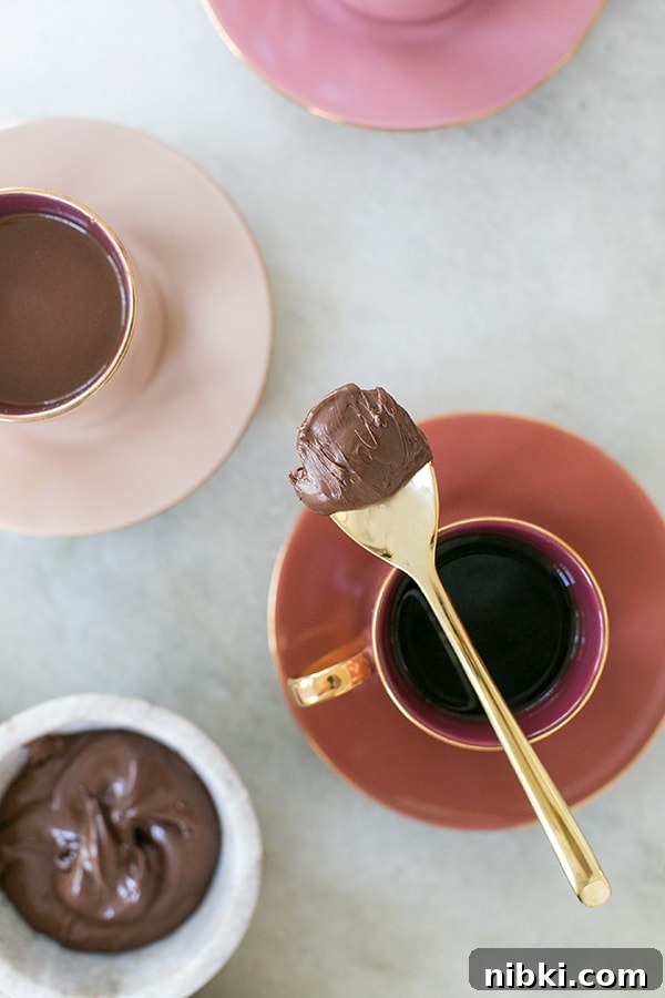 Homemade Chocolate Hazelnut Coffee Recipe 6 Spoon with Nutella on it over a cup of coffee.