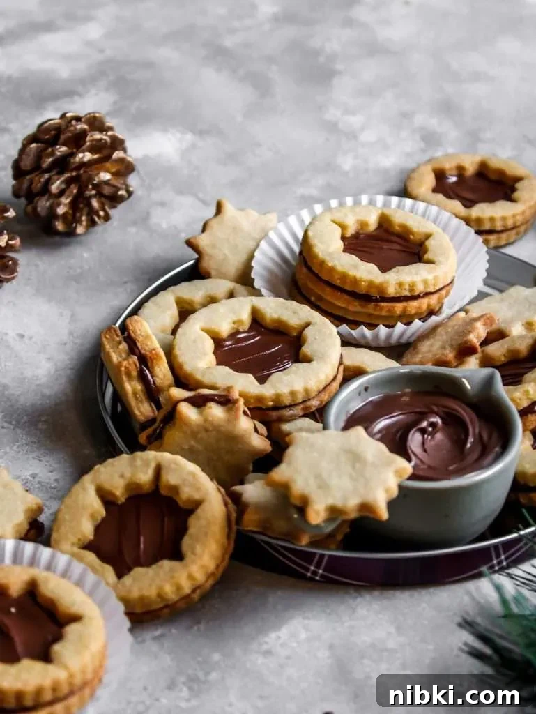 Nutella-Filled Linzer Cookies Recipe 2 filled Nutella Linzer cookies on serving platter (7)