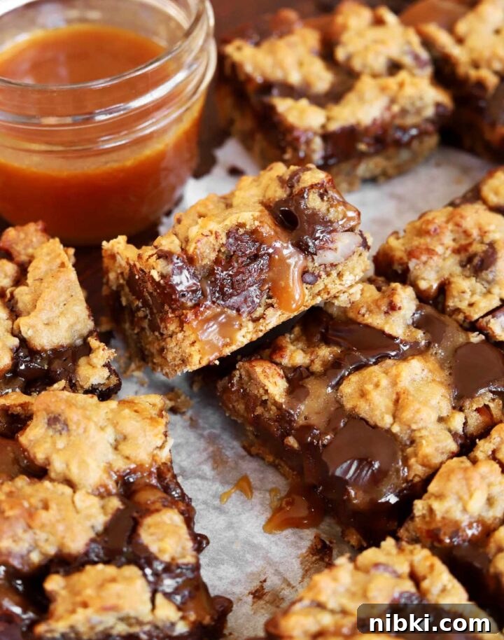 Salted Caramel Oatmeal Chocolate Chip Cookie Bars Recipe 3 sliced caramel oatmeal chocolate chip cookie bars with gooey cross section