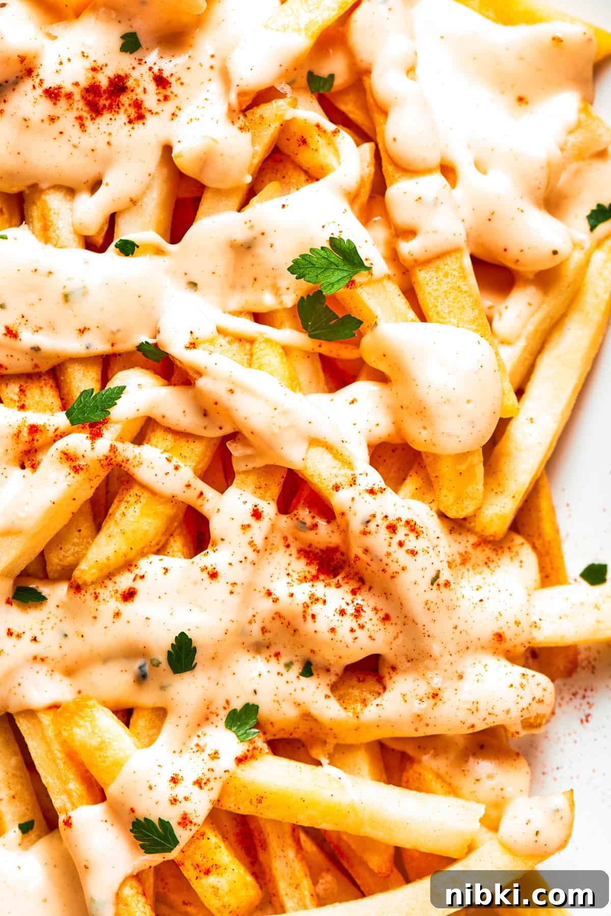 Crispy voodoo fries are drizzled with cheese sauce.