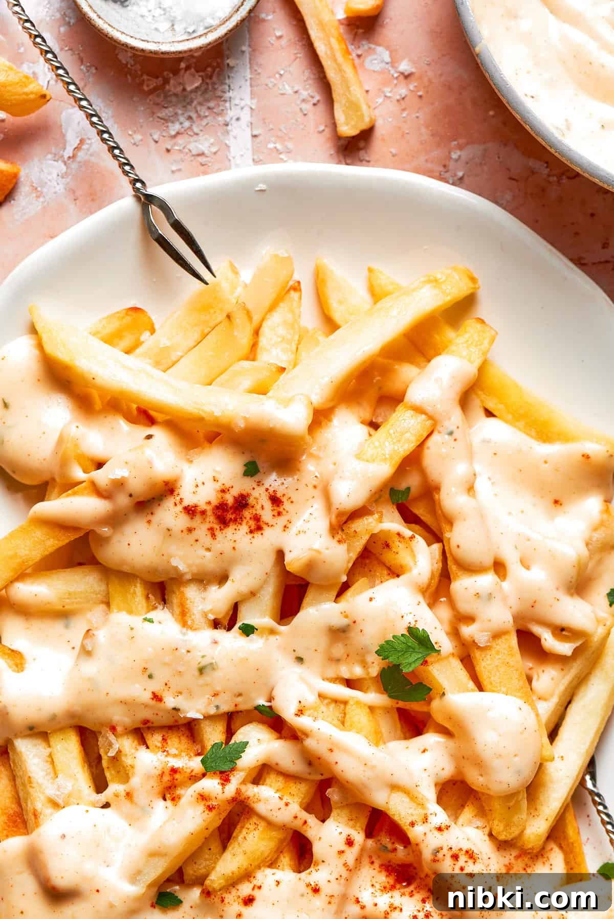 A plate of voodoo fries and a serving utensil.