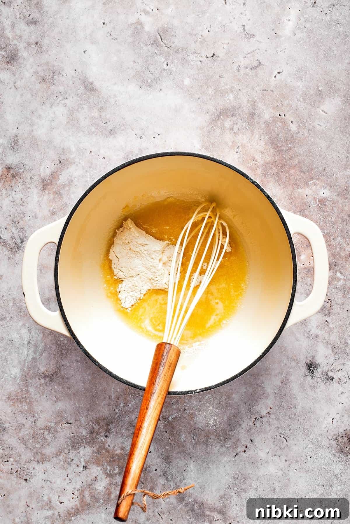 Butter and flour are combined in a pot to make a roux.