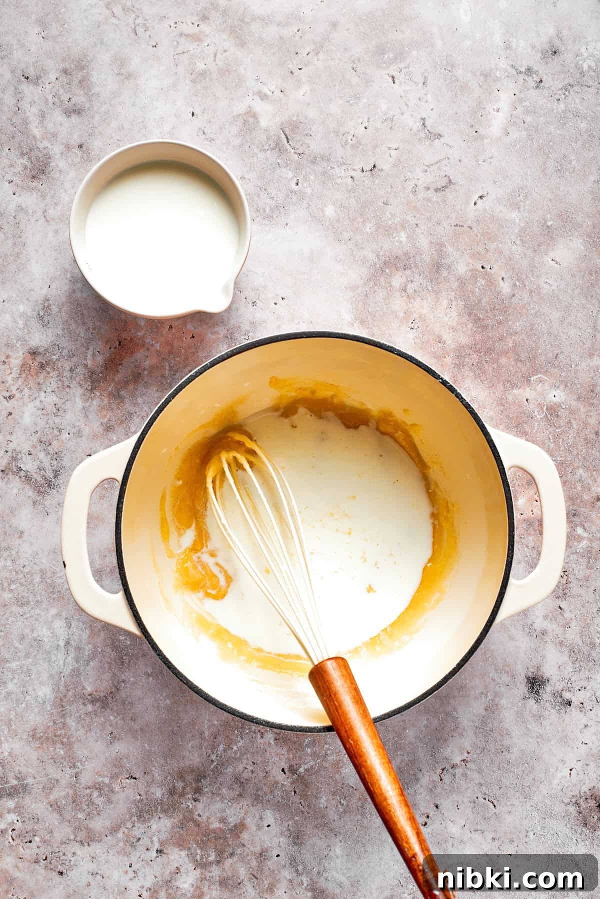 Cream is whisked into a roux.