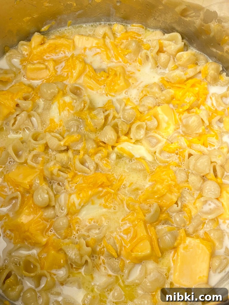 Creamy Instant Pot Mac and Cheese with Velveeta 6 Stirring velveeta cheese, cheddar cheese and evaporated milk into instant pot cooked macaroni
