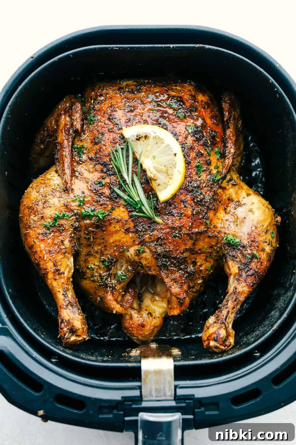 Top view of a whole chicken cooked in an air fryer.