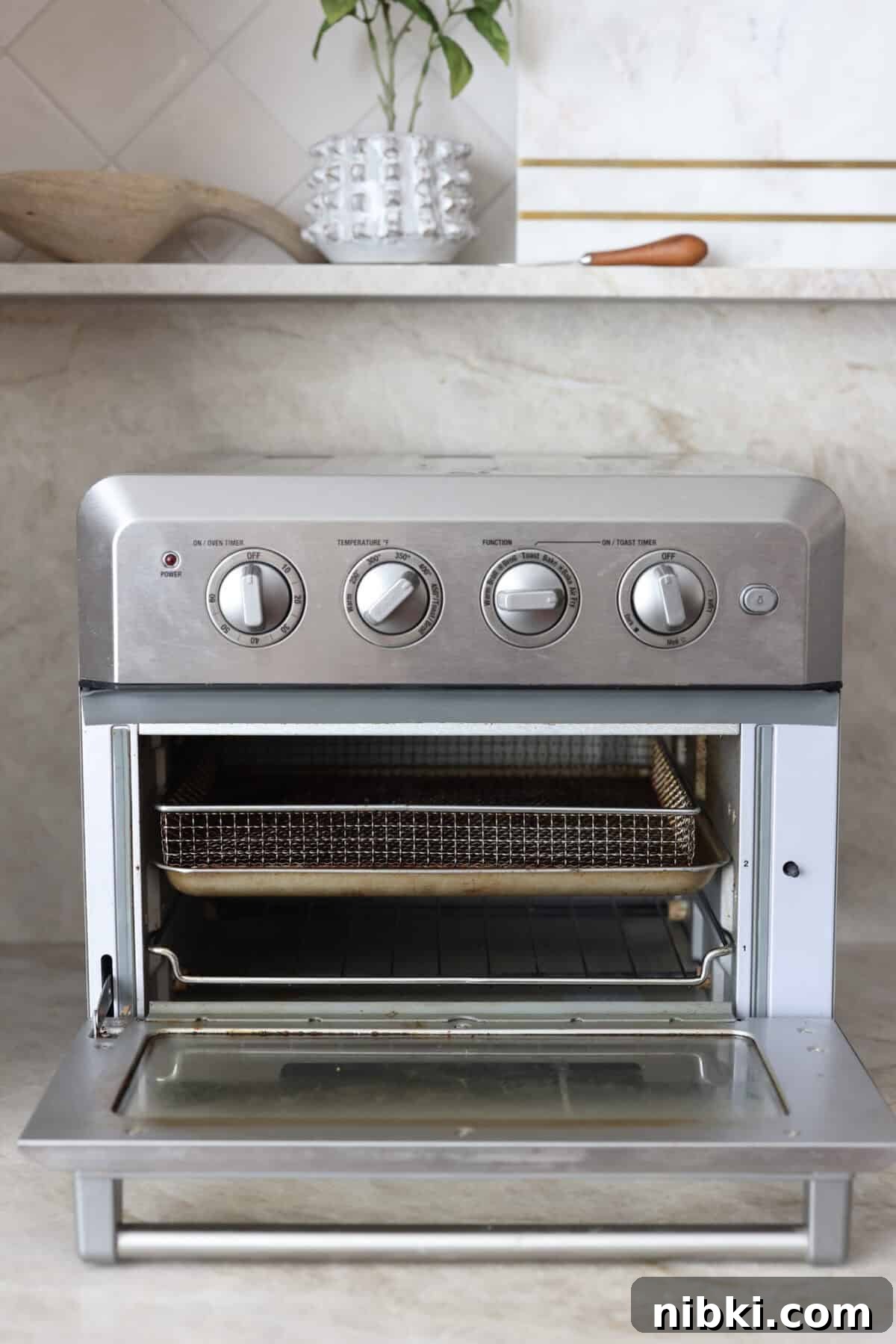 Close view of a toaster oven air fryer with the door open.