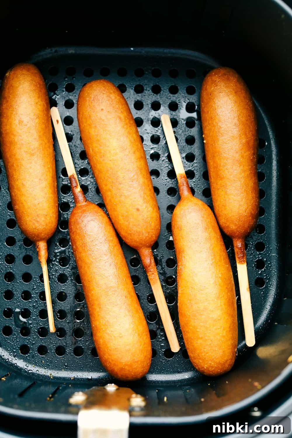 Third photo of corndogs in a basket.