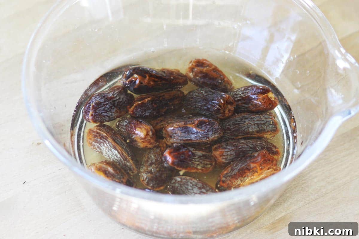 whole medjool dates are soaking in a bowl of water