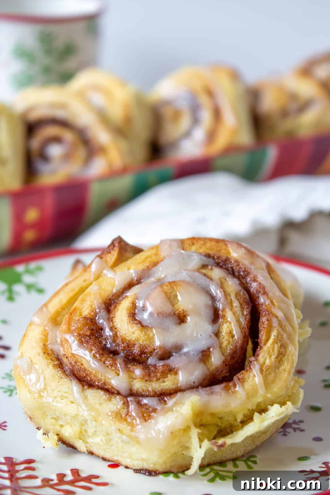 Homemade Cinnamon Rolls with Cream Cheese Frosting 2 A cinnamon roll topped with a drizzled glaze.