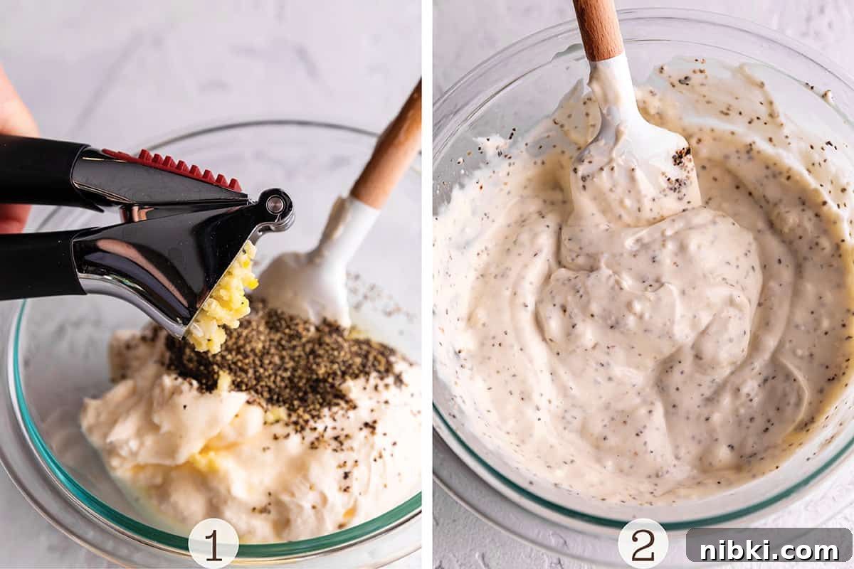 Homemade Lemon Garlic Aioli Recipe 4 A glass bowl with a mayo sauce and garlic being pressed into it.