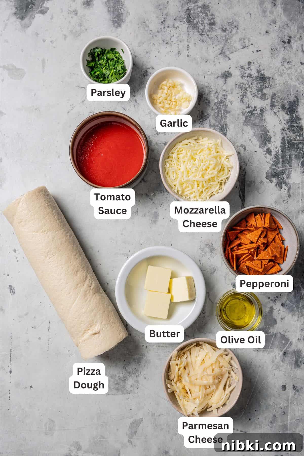 Cheesy pizza rolls are the best and easiest appetizer! Flaky dough gets rolled up with tangy tomato sauce, melty mozzarella, and pepperoni. Pizza roll ingredients with text labels overlaying each ingredient.