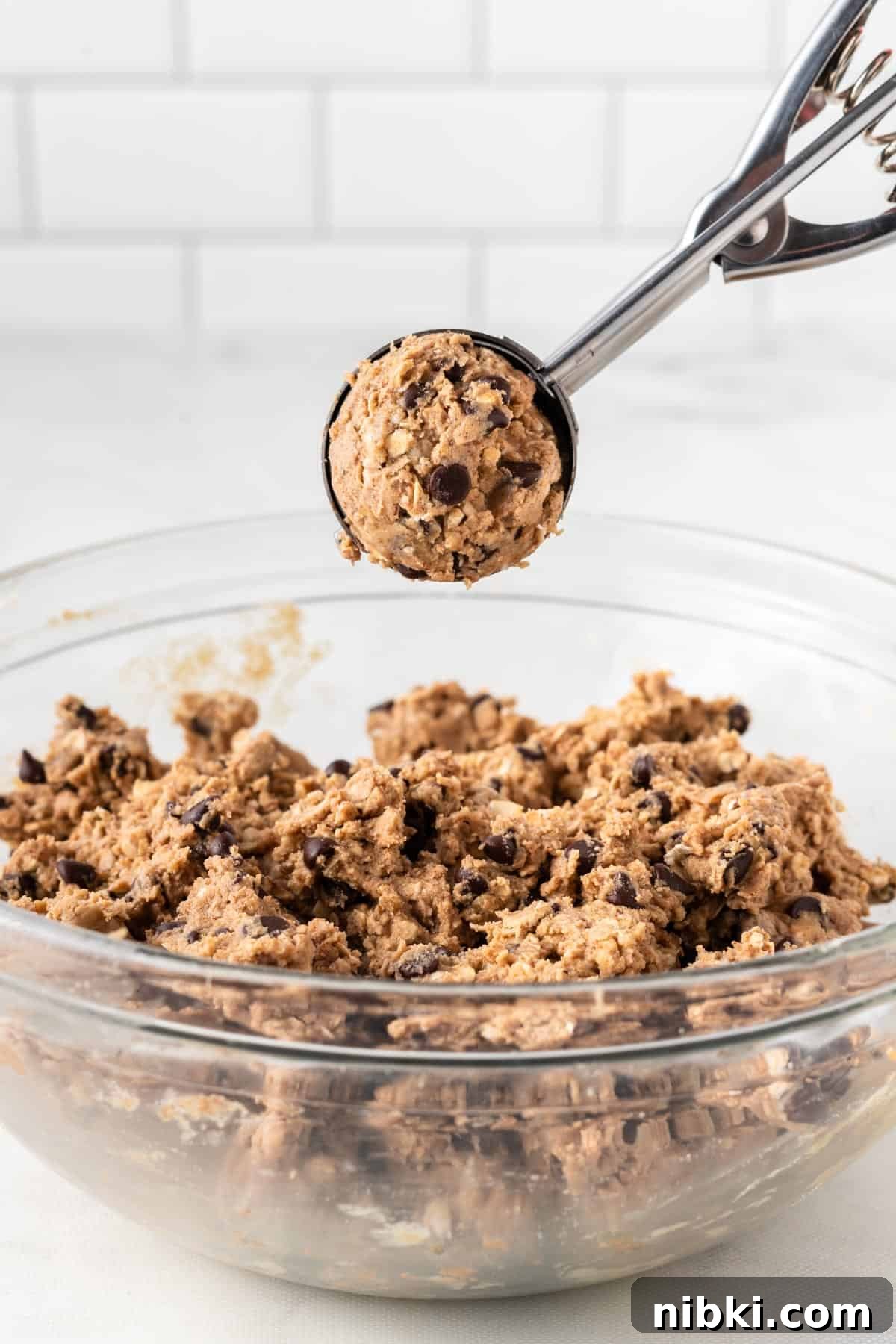 mini cookie scoop holding a scoop of energy ball batter