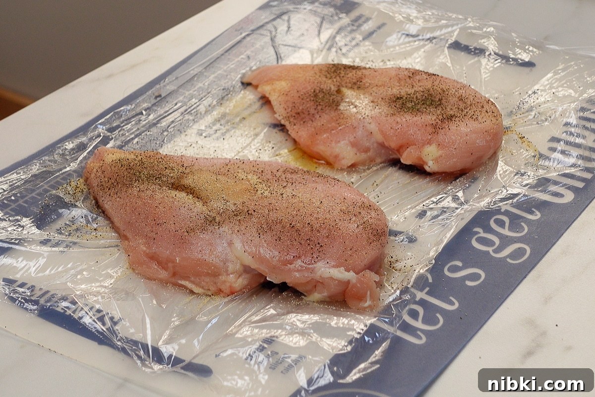 Tender Oven-Baked Chicken Breasts with Garlic and Herbs 5 Two chicken breasts with seasoning.