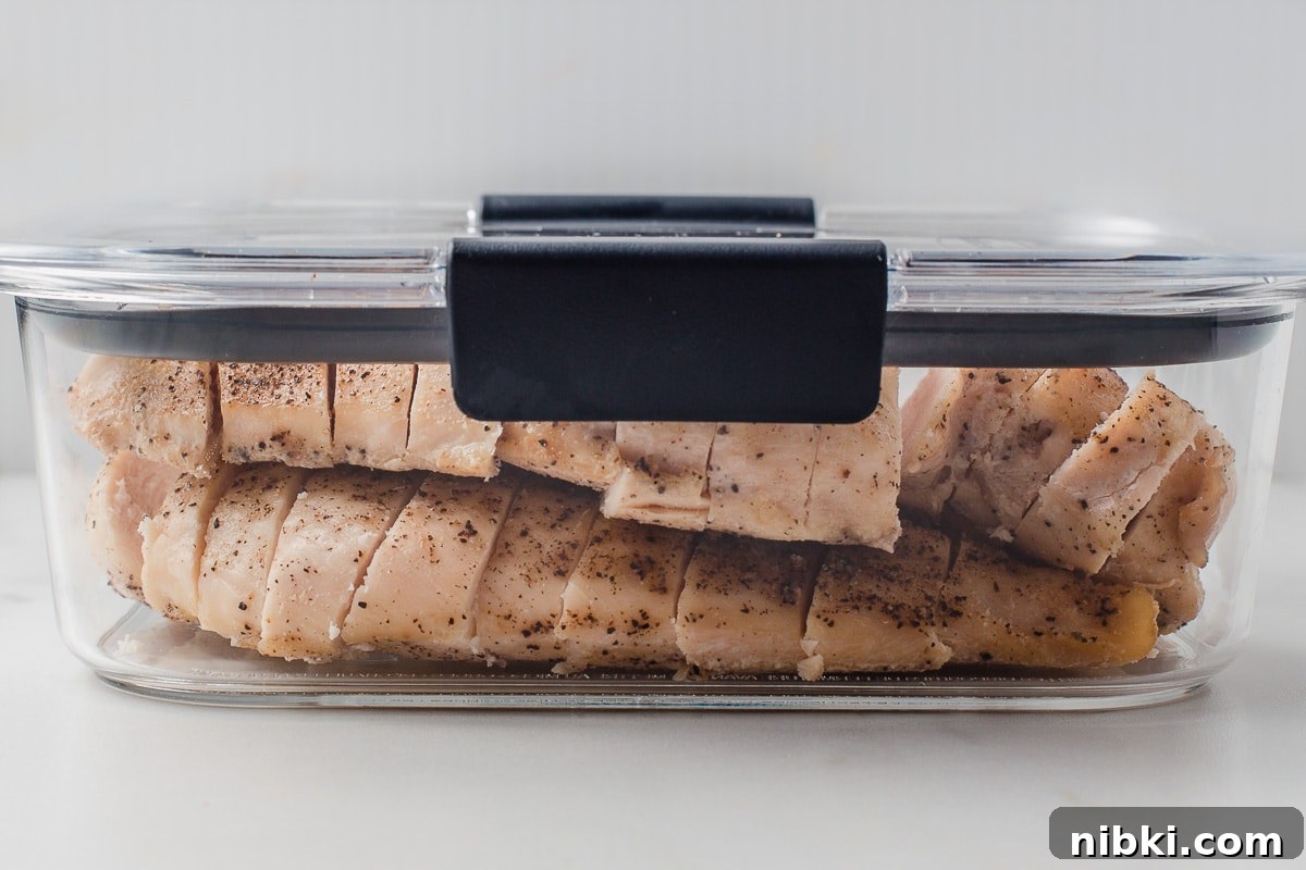 Tender Oven-Baked Chicken Breasts with Garlic and Herbs 8 Baked chicken breast in a meal prep container.