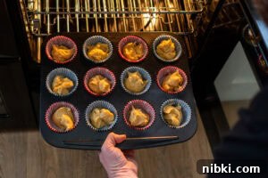 Twelve fairy cakes cooked in a tray coming out the oven