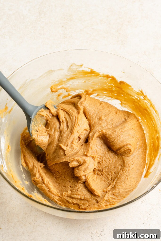 Soft peanut butter fudge in a mixing bowl with a rubber spatula.