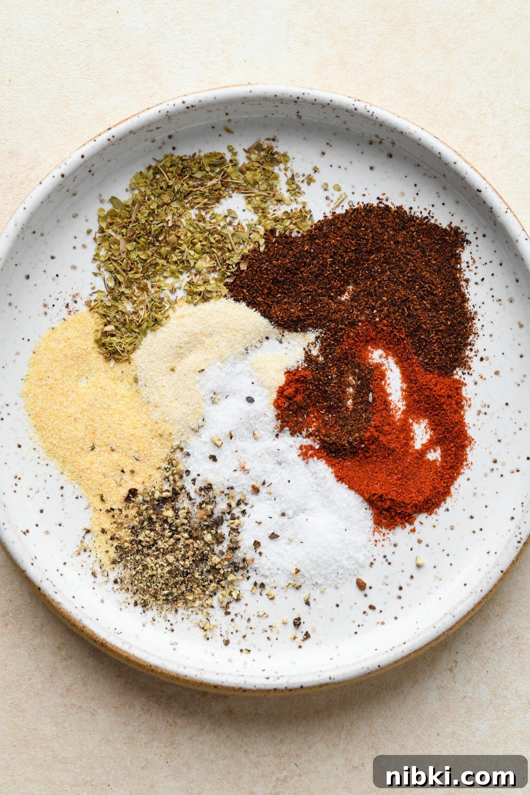 Blackening spices on a small white speckled plate.
