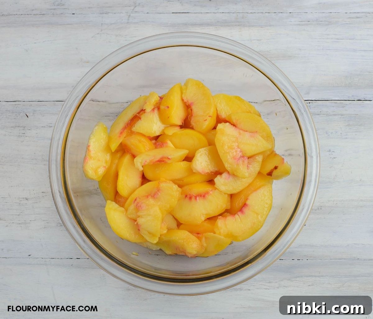 Fresh peaches sliced in a glass bowl.