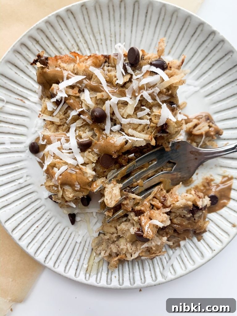 Almond Joy Inspired Chocolate Coconut Baked Oatmeal 2 slice of almond joy baked oatmeal with a fork taking a bite