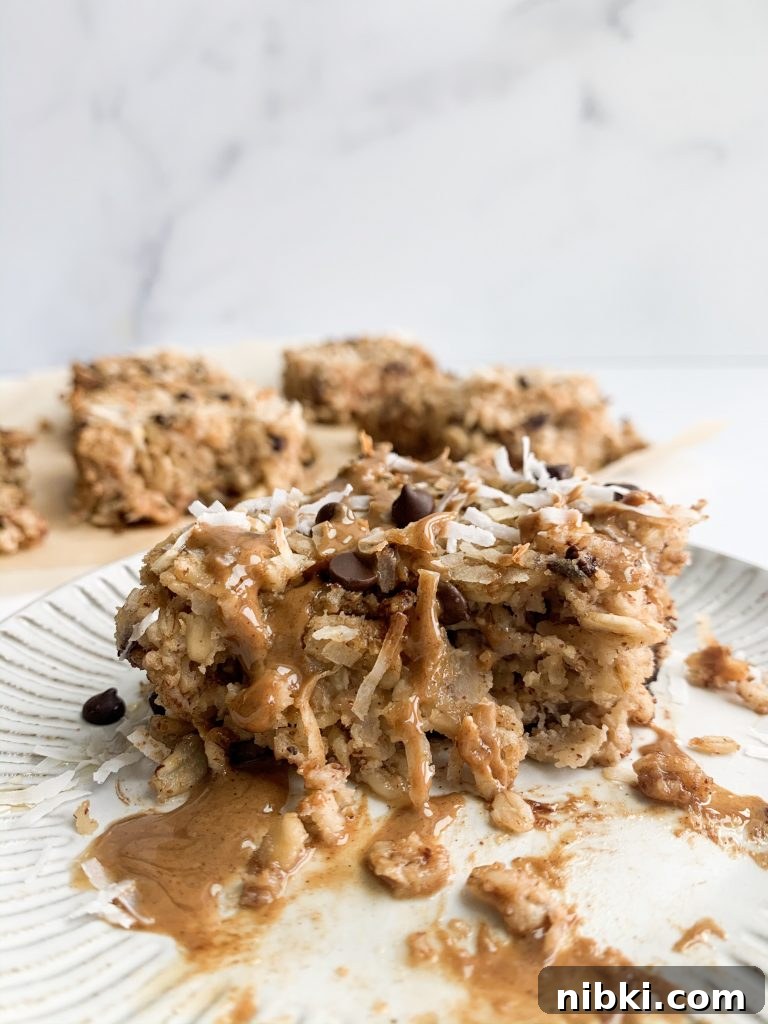 Almond Joy Inspired Chocolate Coconut Baked Oatmeal 4 an oatmeal square topped with almond butter, coconut, and chocolate chips