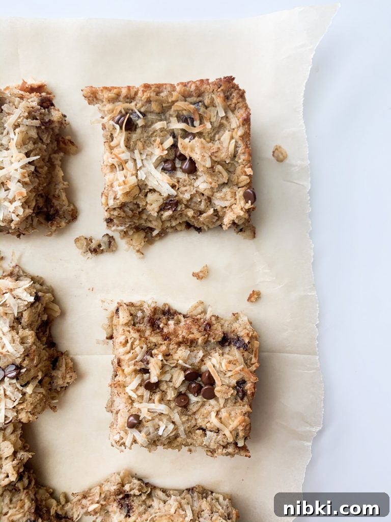 Almond Joy Inspired Chocolate Coconut Baked Oatmeal 6 oatmeal bake squares on parchment paper on a white background