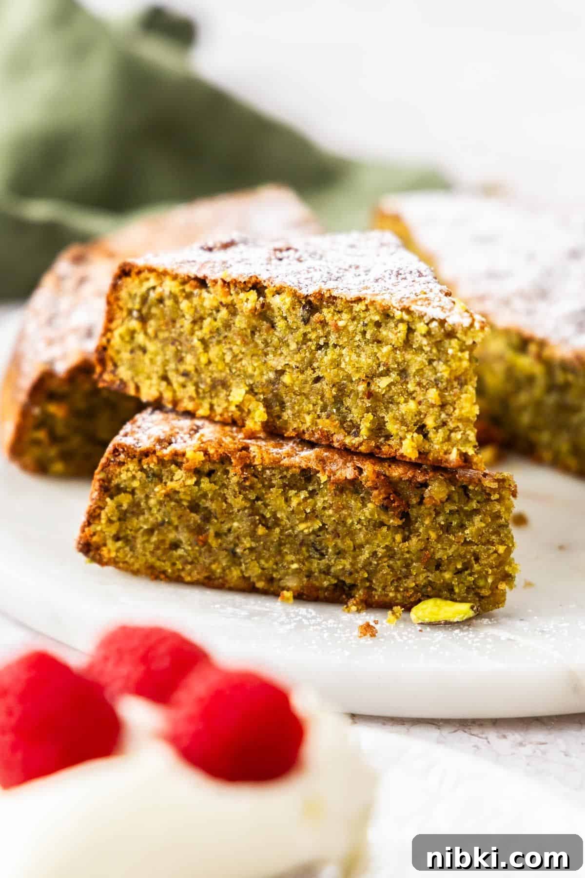 Decadent Flourless Pistachio Cake Recipe: Gluten-Free Dessert 4 Two pieces of Pistachio Cake stacked on top of each other.