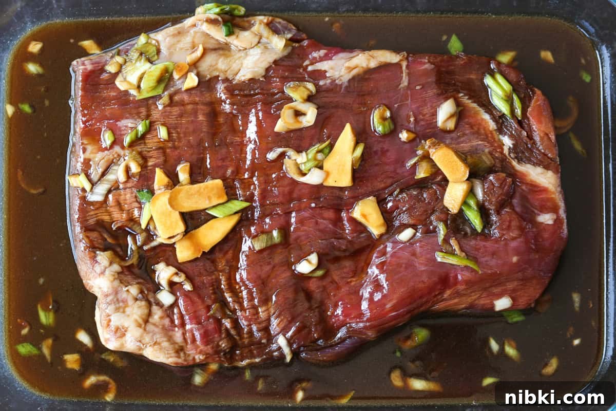 flank steak marinating in glass dish